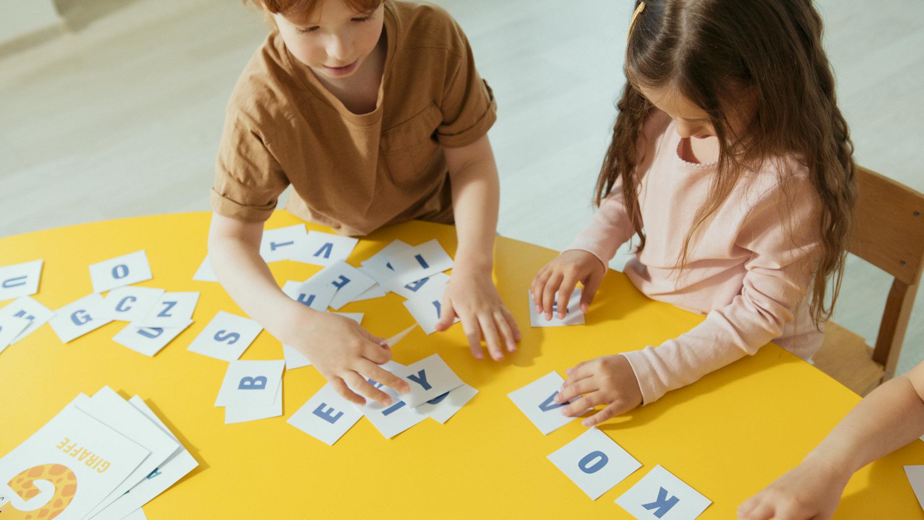 kids holding papers with alphabets