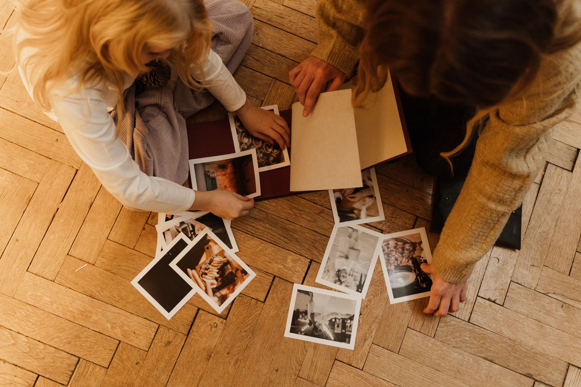 women arranging photographs in an album
